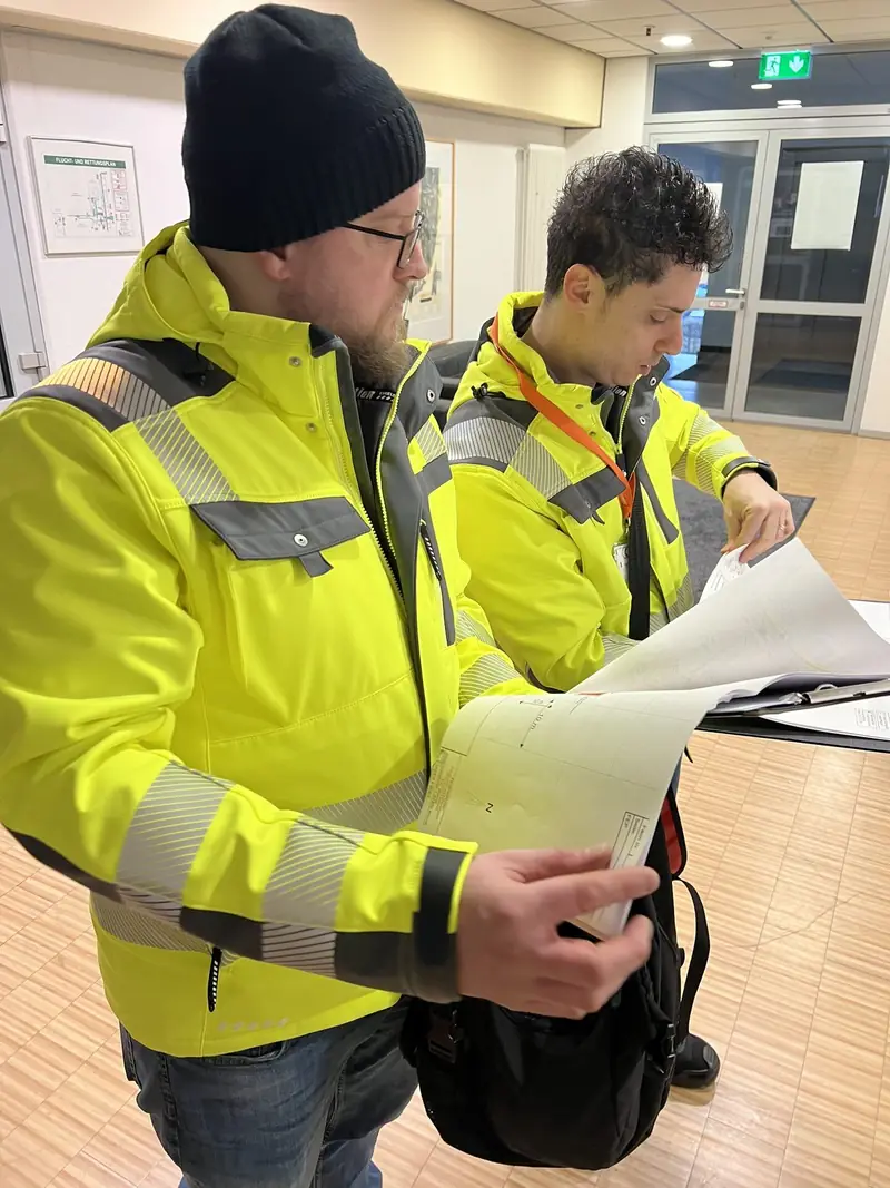 Brandschutzbeauftragte von EHBS Knecht mit Plänen bei einer Begehung im Industriebetrieb