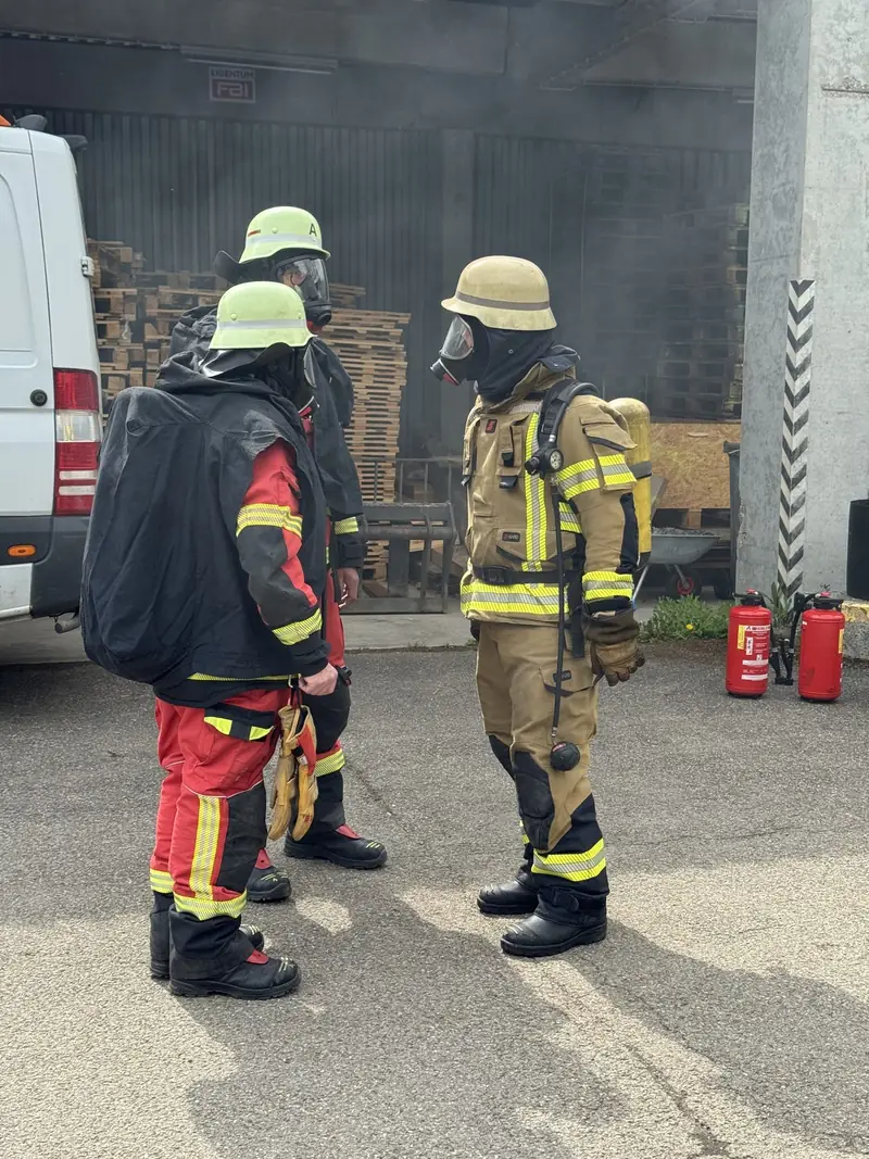 Einsatzkräfte einer Werkfeuerwehr in Schutzausrüstung bei einer Übung