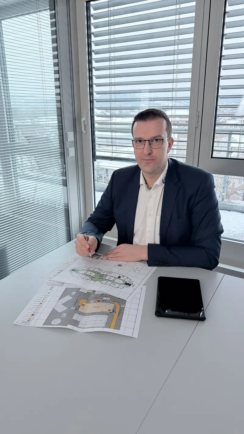Thomas Knecht am Besprechungstisch mit Brandschutzplänen
