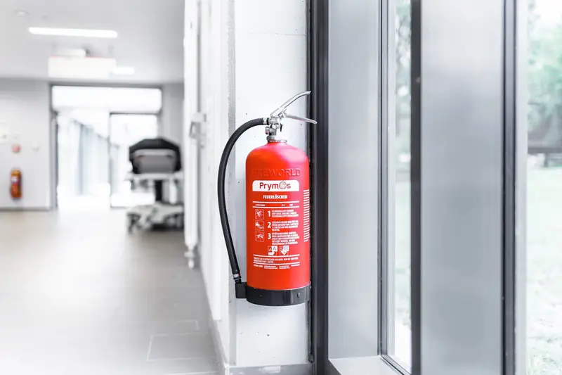 Wartungsfreier Prymos-Feuerlöscher PM10 an der Wand in einem hellen Flur