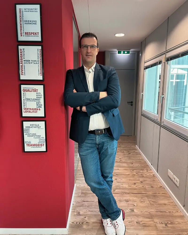 Thomas Knecht, Geschäftsführer von EHBS Knecht, an der Wand mit den Werten des Unternehmens