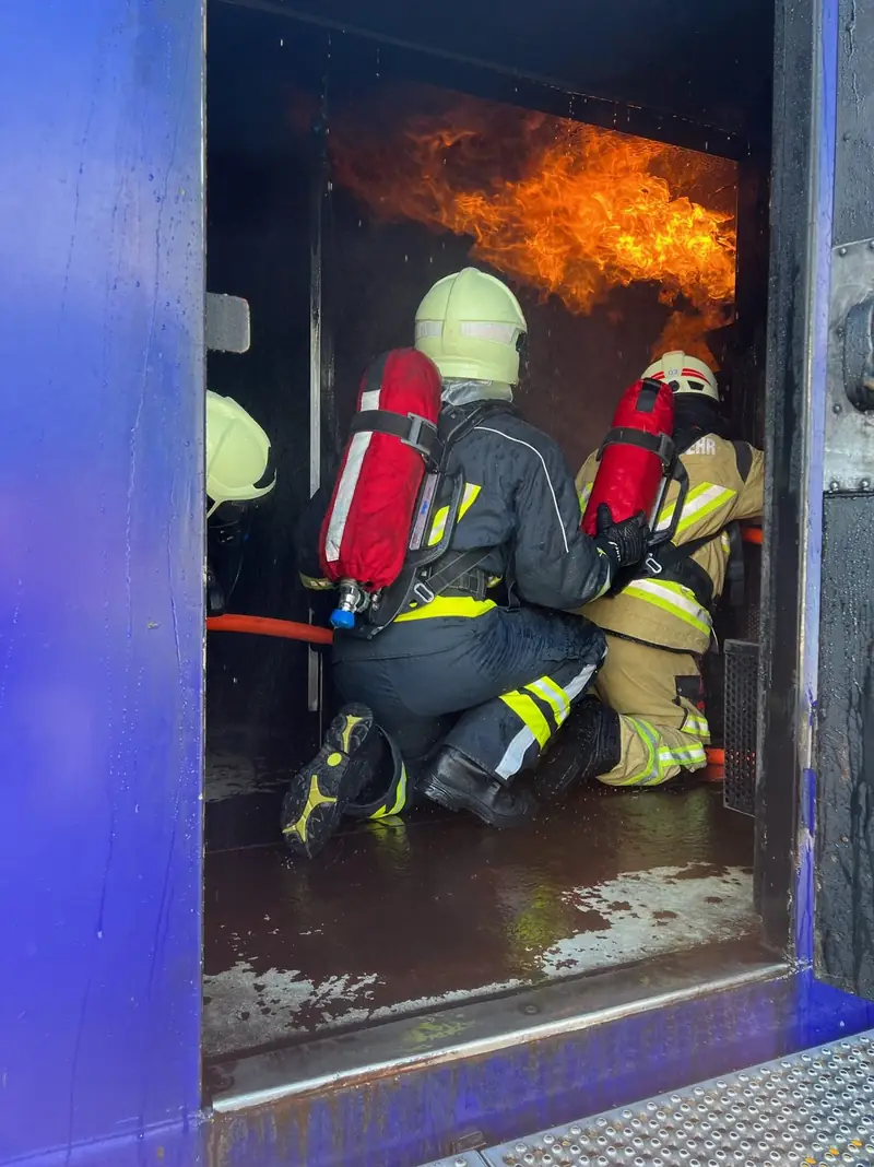 Feuerwehrleute unter Atemschutz in einer Brandsimulationsanlage