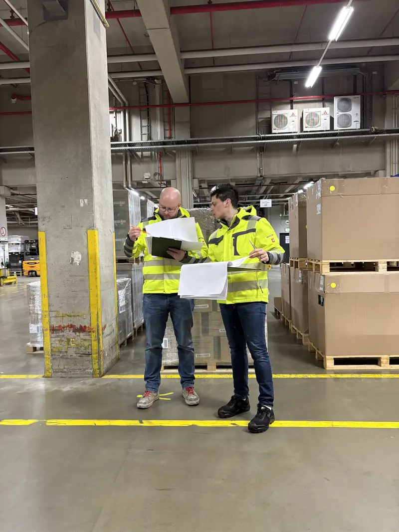 Begehung mit Plan und Warnweste in einer Logistikhalle