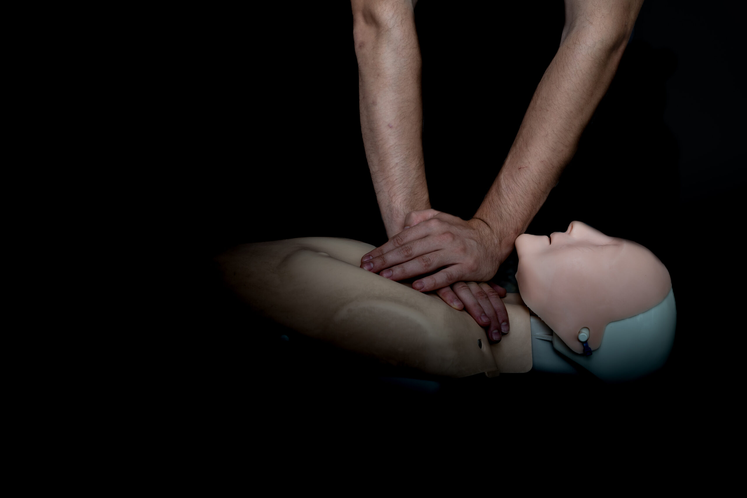 Ersthelfer übt Herzdruckmassage an einer Übungspuppe