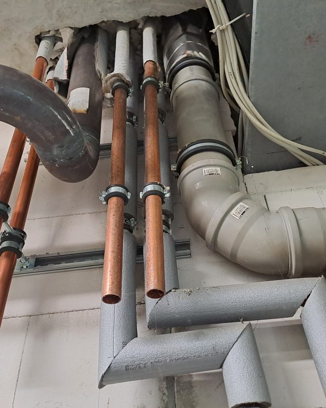 Rohre und Kabel führen durch eine offene Deckenöffnung